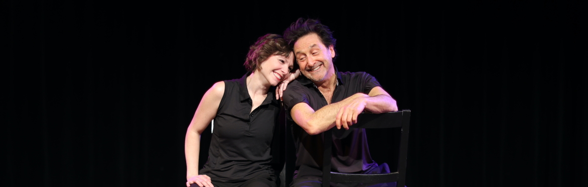 Jordan Batta and Billy Siegenfeld sit on stage smiling to each other.