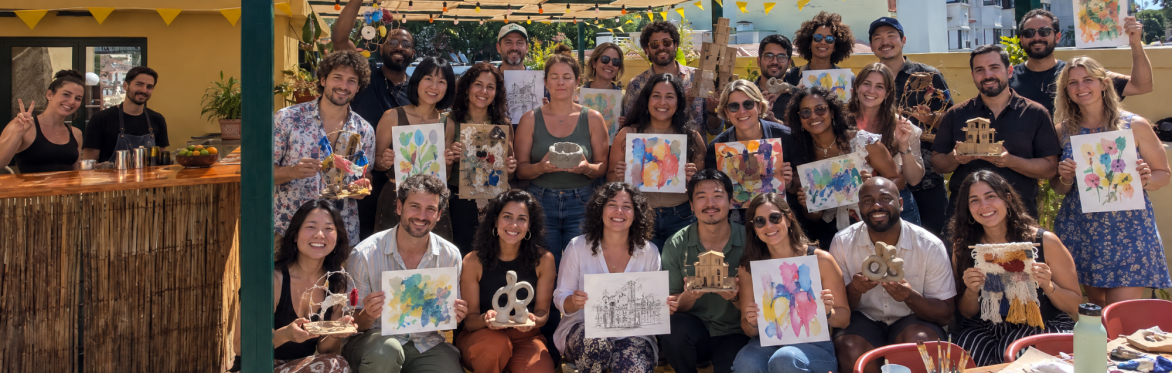 A group of people holding up their artistic creations after a Creative Playground Night.