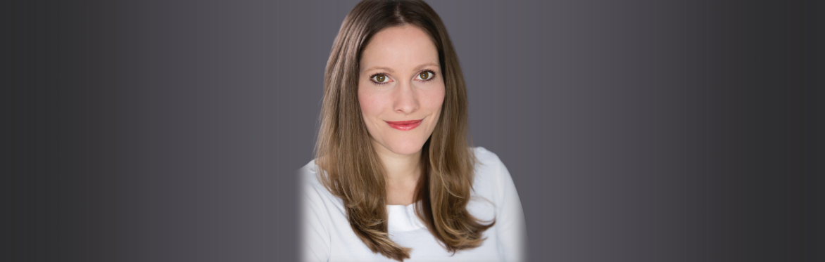 A head and shoulders portrait photograph of Laura Bates, a white woman with light brown, shoulder-length hair. She is smiling at the camera.