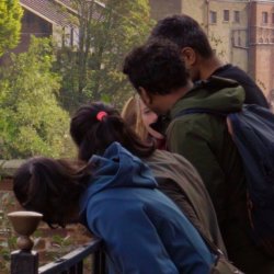 Young people standing beside the River Ouse, observing the water and riverside environment during a York rivers trail activity.
