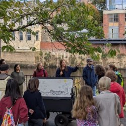 Group gathered beside the River Ouse at North Street Gardens, taking part in a guided York rivers trail discussion and creative engagement activity.