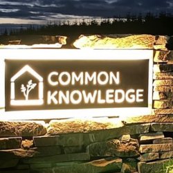 Common Knowledge Sign lit up at night at front entrance