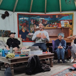 Andy Goldring talking to a group in a hut