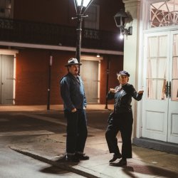 A.W. Cardinal and Jasmine Colette of Blue Moon Marquee standing on a street corner in New Orleans. Blue Moon Marquee will be appearing live at the Axe & Fiddle December 1, 2026