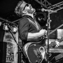 Luke Edney playing guitar and singing