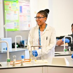 A female student smiling in a science lab