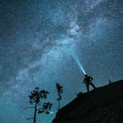 A man standing under the Milky Way