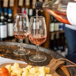 rose with being poured from a bottle and a cheese board