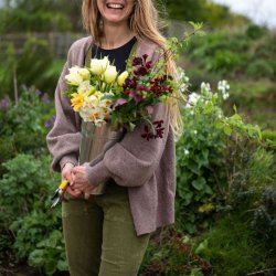 Woman holding bucket of British spring flowers