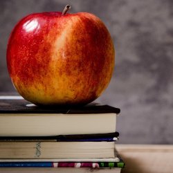 An apple rests on top of some books