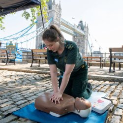 A photo of two people performing CPR and operating a defibrillator
