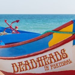 a boat on the portuguese beach with the name "deadheads in portugal"