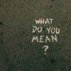 The words "What do you mean?" have been painted onto a pavement