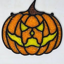 Wood frame in the shape of a pumpkin with a witch's hat filled with a rainbow of vibrantly dyed crushed glass