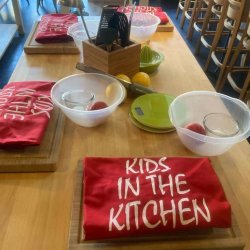 Cooking bowls, ingredients and aprons on a wooden worktop