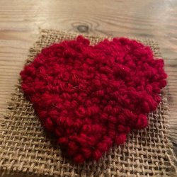 A handmade rag rug heart on a hessian backing