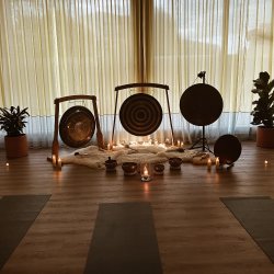 3 large gongs in wooden stands among candles