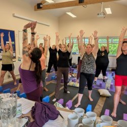 A group of women practicing yoga, enjoying the strength of warrior 1