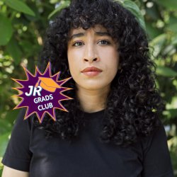 Jem, a white woman with purple glasses, smiles to camera