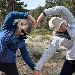 two women combining hiking and yoga in the woods