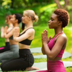 women in the park, meditating on yoga blocks