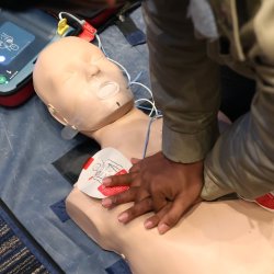 Man practicing CPR on a manikin