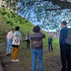 An image of a the Uncomfortable York Tour, with people listening to a guide as they talk about the history of Chocolate in the city.