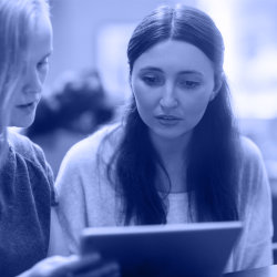 Two women looking at a tablet screen together