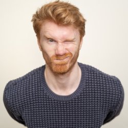 Sam Adamson leaning forward and winking at the camera