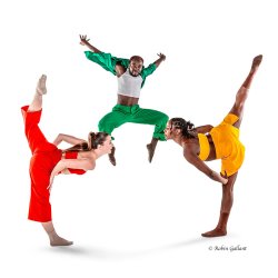 Three dancers dancing in bright primary colors