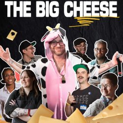 A man in a cow costume with with a microphone poses in front of a team of cheesemongers.