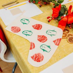 Lino printed christmas stocking with penguins and Christmas baubles