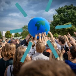 People gathered outside holding a globe