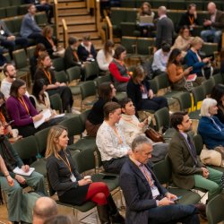 An audience sat in a lecture hall listening to a session