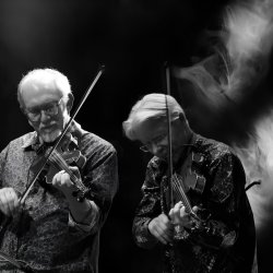 The image features Darol Anger and Bruce Molsky in black and white, standing and playing their fiddles
