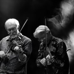 The image features Darol Anger and Bruce Molsky in black and white, standing and playing their fiddles