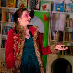 Madame Thespia in a furry coat with red eye make up and glitter
