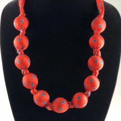 Image of a necklace that has been made from a mans tie and large beads