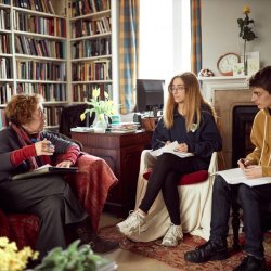 One Tutor and two students having a tutorial in an office.