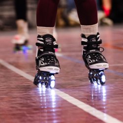 Two friends hold hands while skating