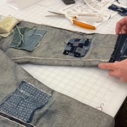 A pair of an inside-out jeans mended with various denim patches.