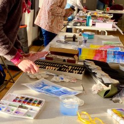 people painting on tables in an art class