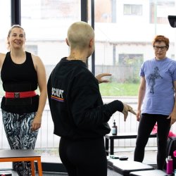Alt text for lead image   An image of a personal trainer in a gym talking to two clients