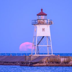 The full moon rising behind the Grand Marais lighthouse.