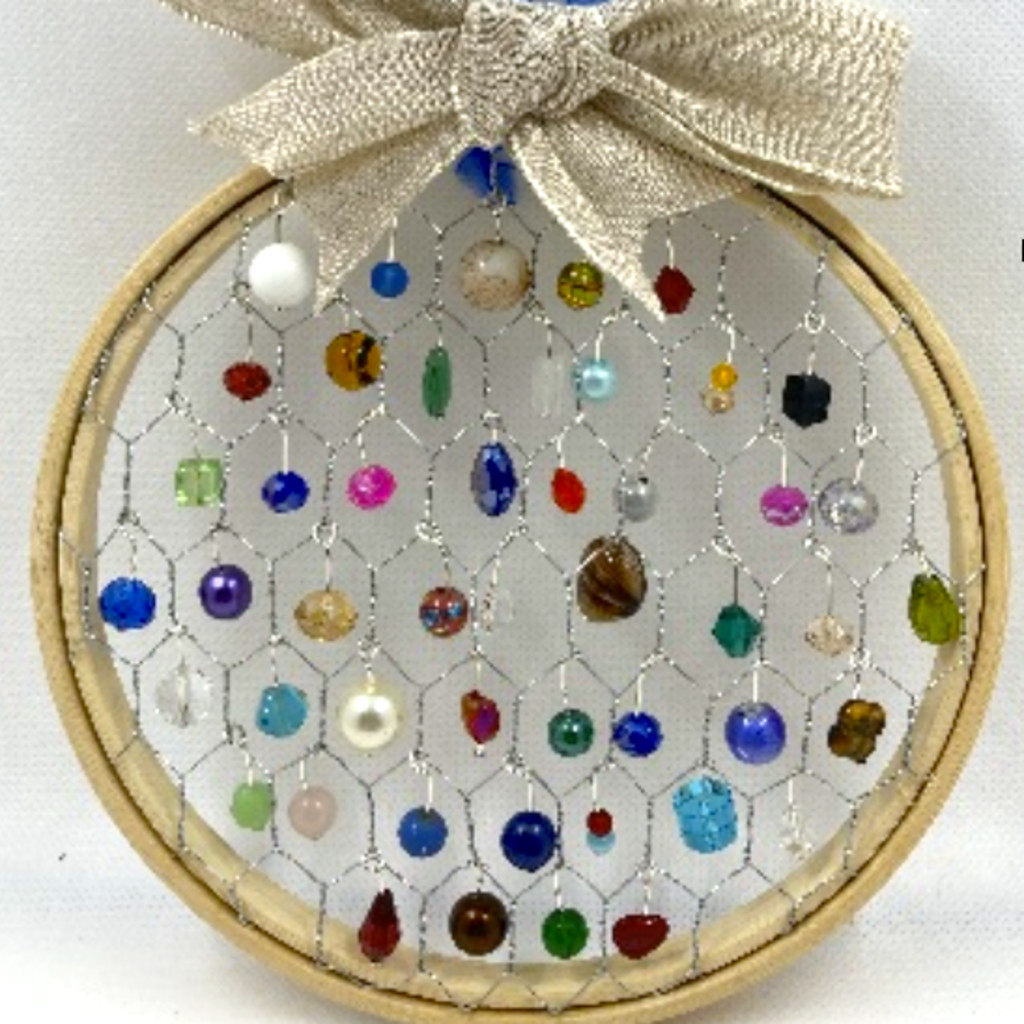 Embroidery hop covered with chicken wire and decorated with colourful beads to make to suncatcher.