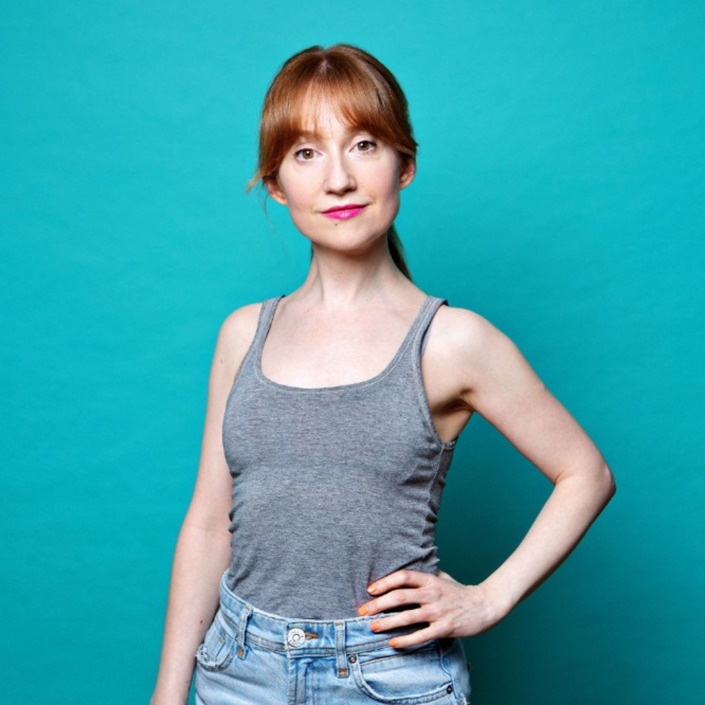woman with ginger hair looks to camera