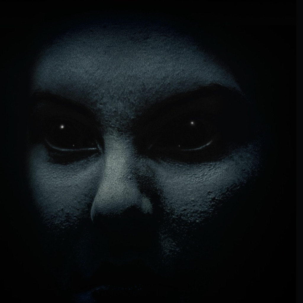 A scared face standing still in the dark