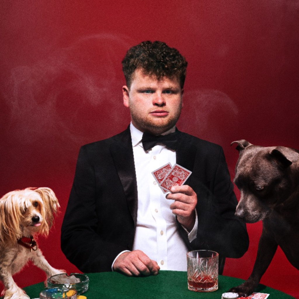 A photo of Dan Tiernan at a poker table with two dogs