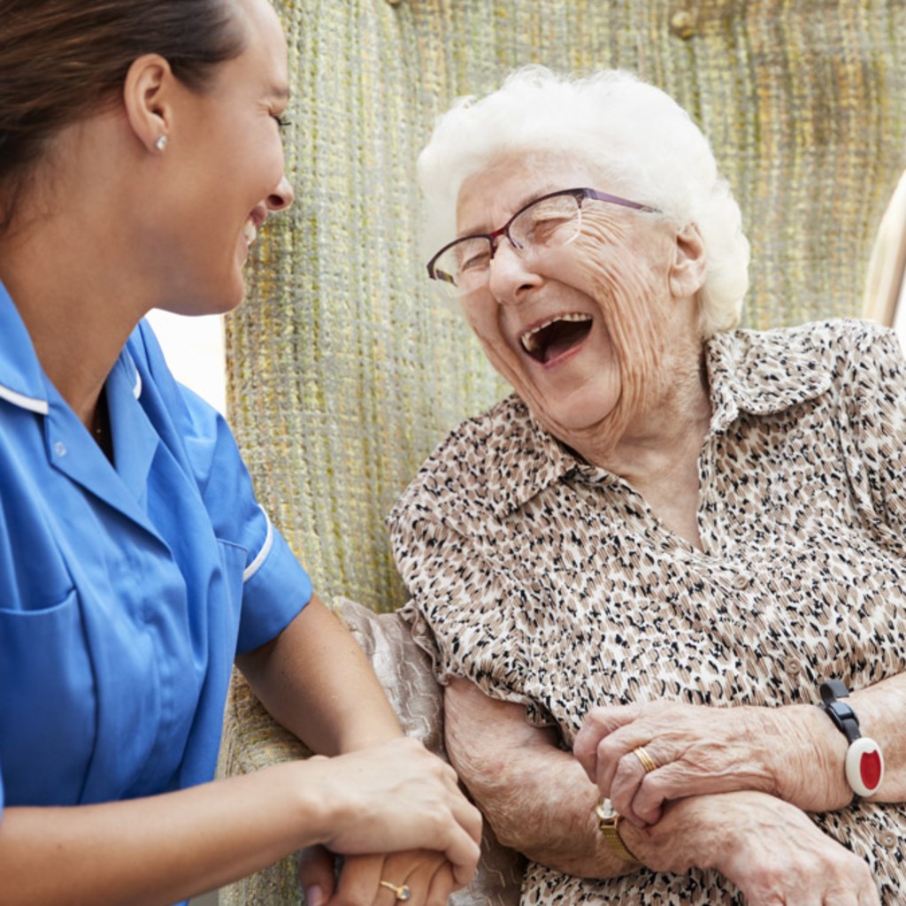 elderly woman laughing with medical professional