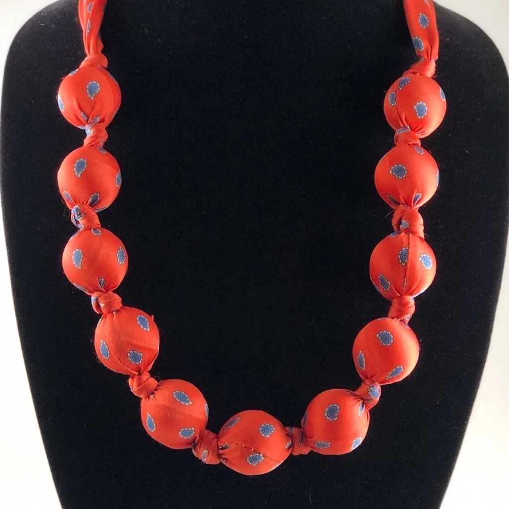 Image of a necklace that has been made from a mans tie and large beads